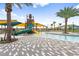 Community pool and splash pad featuring plenty of seating, shade, and tropical palm trees at 11944 Sunsail Ave, Orlando, FL 32832