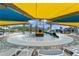 Community pool featuring a slide and splash pad area, along with colorful umbrellas and lounge chairs at 11944 Sunsail Ave, Orlando, FL 32832
