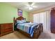 Cozy bedroom featuring a wooden bed frame, ceiling fan, and comfortable striped bedding with matching wood furniture at 131 Country Creek Ln, Kissimmee, FL 34746