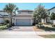 Two-story home with paver driveway, grey siding, clay tile roof, and manicured landscaping at 1340 Blue Stem Ln, Winter Park, FL 32792