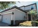 Angle view of two-story home showcasing white trim, grey siding, and desert landscaping at 1340 Blue Stem Ln, Winter Park, FL 32792