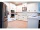 Spacious white kitchen featuring stainless steel appliances and modern cabinetry at 1340 Blue Stem Ln, Winter Park, FL 32792