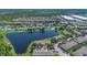 Picturesque aerial view of lake community, surrounded by houses, trees, and lawns at 13480 Applerose Ln # 19, Orlando, FL 32824
