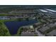Aerial view of a complex beside a serene lake, surrounded by homes, lawns, and roadways at 13480 Applerose Ln # 19, Orlando, FL 32824