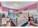 Cozy bedroom featuring a bunk bed, wood floors, and bright pink accent wall at 13480 Applerose Ln # 19, Orlando, FL 32824