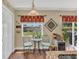 Cozy breakfast nook featuring outdoor views, red floral curtains, and a decorative wine storage area at 13480 Applerose Ln # 19, Orlando, FL 32824