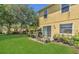 A large backyard with well maintained lawn, exterior house view, and patio with seating at 13480 Applerose Ln # 19, Orlando, FL 32824