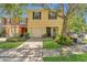 Two-story townhome with a yellow facade, attached garage, and well-maintained landscaping at 13480 Applerose Ln # 19, Orlando, FL 32824