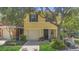 Charming yellow two-story townhome with a one car garage and welcoming front porch at 13480 Applerose Ln # 19, Orlando, FL 32824