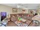 Living area with a large brown sectional sofa, ceiling fan, and decorative accents at 13480 Applerose Ln # 19, Orlando, FL 32824