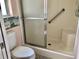 Bathroom with walk in shower, seat, and safety bar at 144 Costa Mesa Dr, Lady Lake, FL 32159