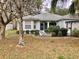 Beautiful home with a screened front entryway, tidy landscaping, and gray driveway at 144 Costa Mesa Dr, Lady Lake, FL 32159