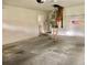 Well-lit garage with concrete flooring offering extra space, ladder, and a door leading to the laundry room at 144 Costa Mesa Dr, Lady Lake, FL 32159