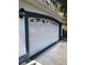 Close-up of white two-car garage door with decorative windows and gray trim at 144 Costa Mesa Dr, Lady Lake, FL 32159