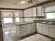 Bright kitchen with a breakfast bar, tiled floors, ample counter space, and two large windows at 144 Costa Mesa Dr, Lady Lake, FL 32159