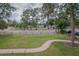 A sidewalk leads to a charming park-like setting with mature trees and a well-maintained lawn at 1505 W Lake Cannon Nw Dr, Winter Haven, FL 33881