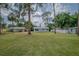 Spacious front yard with large trees enhancing the property's curb appeal at 1505 W Lake Cannon Nw Dr, Winter Haven, FL 33881