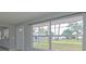 Bright living room featuring a large window with views of the lush backyard and street at 1505 W Lake Cannon Nw Dr, Winter Haven, FL 33881