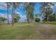 Picturesque view of the expansive yard with mature trees and distant lake views at 1505 W Lake Cannon Nw Dr, Winter Haven, FL 33881