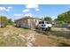 The back of the home features a cluttered yard with ladders, a work van, and an above-ground pool at 1508 Roger Babson Rd, Orlando, FL 32808