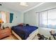 This bedroom features a blue comforter, wooden dresser, and bright windows at 1508 Roger Babson Rd, Orlando, FL 32808
