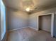 A carpeted bedroom with a ceiling fan and a closet space is waiting for personalization at 151 Prestwick Dr, Davenport, FL 33897