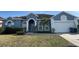 Charming single-story home with a well-manicured lawn, arched entryway, and attached two-car garage at 151 Prestwick Dr, Davenport, FL 33897