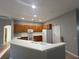 Functional kitchen featuring white appliances, light wood cabinets, and a breakfast bar at 151 Prestwick Dr, Davenport, FL 33897