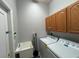 Utility room with washer, dryer, sink, and cabinet combining practicality and efficiency at 151 Prestwick Dr, Davenport, FL 33897