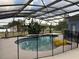 Screened-in pool surrounded by tropical plants and protected by a safety fence at 151 Prestwick Dr, Davenport, FL 33897
