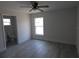 Bedroom featuring wood-look flooring, ceiling fan, and en-suite bathroom at 16648 Sw 25Th Ct, Ocala, FL 34473