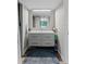 Bright bathroom with a gray floating vanity, chrome fixtures, a large mirror, and dark tile flooring at 170 Lago Vista Blvd, Casselberry, FL 32707