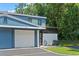 Charming blue townhome featuring a one-car garage, a covered carport and a private front patio at 170 Lago Vista Blvd, Casselberry, FL 32707