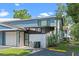 Charming blue townhome featuring a one-car garage, a covered carport and a private front patio at 170 Lago Vista Blvd, Casselberry, FL 32707
