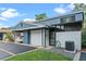 Charming blue townhome featuring a one-car garage, a covered carport and a private front patio at 170 Lago Vista Blvd, Casselberry, FL 32707