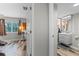 Hallway view of a bathroom with a gray vanity and adjacent room with hardwood floors at 170 Lago Vista Blvd, Casselberry, FL 32707