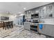 Modern kitchen with stainless steel appliances, gray cabinetry, and a dining table at 170 Lago Vista Blvd, Casselberry, FL 32707