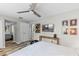Comfortable main bedroom featuring wood-look floors, ceiling fan, and a wall-mounted television above a wooden console table at 170 Lago Vista Blvd, Casselberry, FL 32707