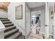 Carpeted stairway with wall art leading to a well lit room with tiled floors through a door opening at 170 Lago Vista Blvd, Casselberry, FL 32707