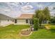 View of the backyard featuring green grass, small garden, and adjacent screened in porch at 17567 Se 81St Parnassus Ct, The Villages, FL 32162
