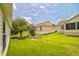 Well-manicured backyard with lush green lawn, mature tree, and tidy landscaping at 17567 Se 81St Parnassus Ct, The Villages, FL 32162