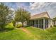 Spacious backyard featuring a screened-in porch and lush lawn perfect for outdoor activities at 17567 Se 81St Parnassus Ct, The Villages, FL 32162