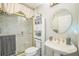 Bathroom featuring a glass-enclosed shower, pedestal sink, and a mirrored medicine cabinet for storage at 17567 Se 81St Parnassus Ct, The Villages, FL 32162