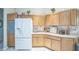 Well-lit kitchen with wooden cabinetry and modern appliances for Gathering meals at 17567 Se 81St Parnassus Ct, The Villages, FL 32162