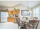 Cozy eat-in kitchen with wooden cabinetry, tile backsplash, and a charming chandelier above the dining table at 17567 Se 81St Parnassus Ct, The Villages, FL 32162