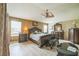 Spacious main bedroom features a ceiling fan, wood-look flooring, and coordinated dark wood furniture at 17567 Se 81St Parnassus Ct, The Villages, FL 32162