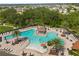 Aerial view of community pool with ample seating, splash pad and sunshades amidst lush tropical landscaping at 1797 Red Canyon Dr, Kissimmee, FL 34744