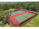 Aerial view of community tennis courts with green and red hard surface and black chain link fence at 1797 Red Canyon Dr, Kissimmee, FL 34744