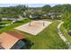 Aerial view of community sand volleyball court surrounded by lush green grass and trees at 1797 Red Canyon Dr, Kissimmee, FL 34744