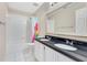 Bathroom featuring double sinks with black countertops, a tub with a colorful curtain, and tiled floors at 1837 Sweetwater West Cir, Apopka, FL 32712
